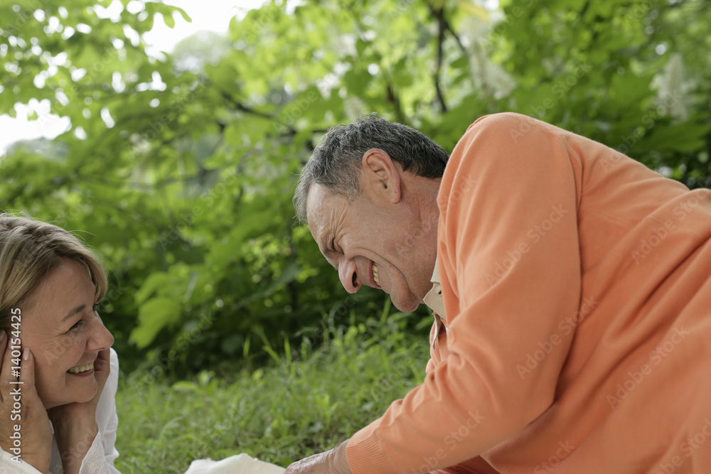 Happy mature couple lying on grass Happy mature couple lying on grass
