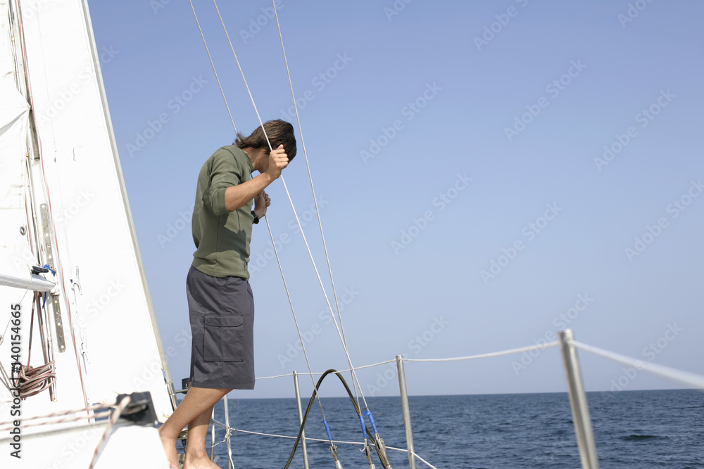 Man standing on a sailboat