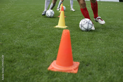 Fotografi Soccer player running slalom with football around marks
