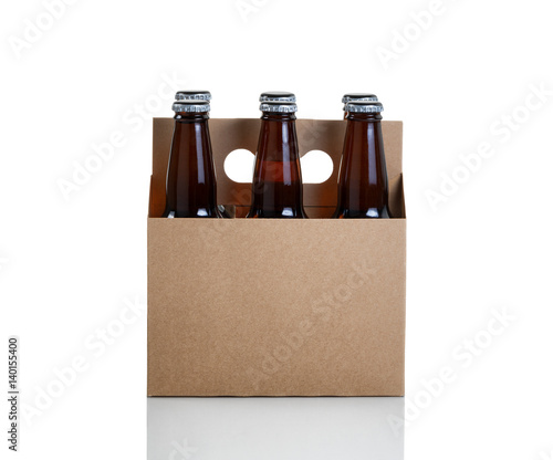 Six pack of bottled beer in generic brown cardboard carrier on white background