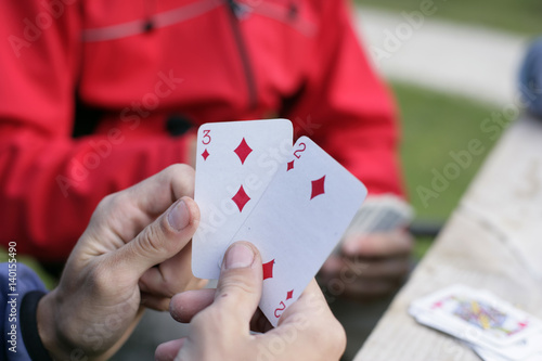 Hands holding two play cards