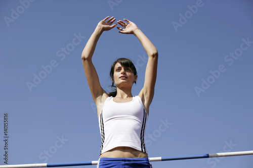 Woman in front of a high jump bar