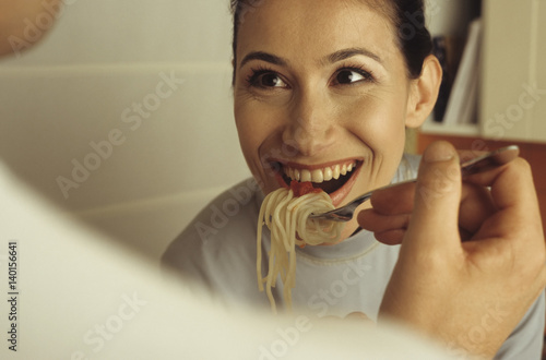 Man feeding his Girlfriend with a forkfull of Spaghetti - Love - Cooking - Dinner