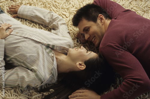 Young Man lying Head to Head with his Girlfriend on a Carpet - Relationship - Love - Home - Living Room photo