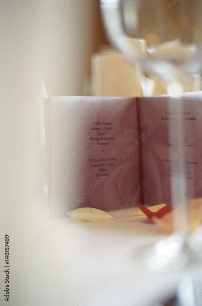Fototapeta premium Menu Card on a Table with Rose Petals on it - Decoration - Party - Wedding