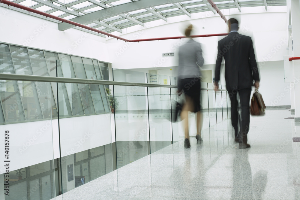 Two businesspeople walking over a corridor Two businesspeople walking over a corridor