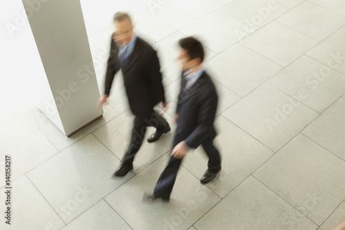 Two businessmen walking in lobby, Munich, Bavaria, Germany