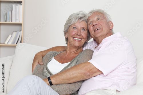 Senior couple hugging on sofa