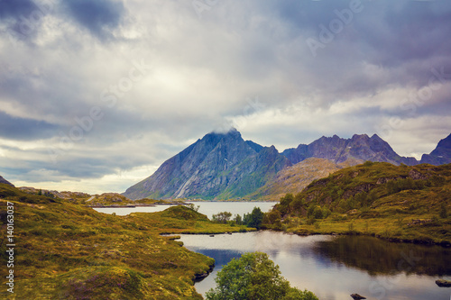 Mountain landscape. Rocky shore of mountain lake in rainy autumn morning. Beautiful nature Norway.