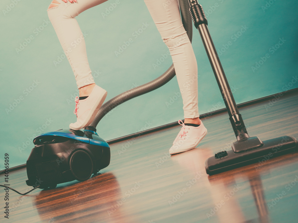 Fototapeta premium Woman legs and vacuum cleaner