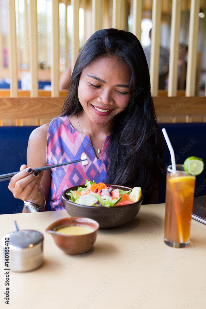 Young adult girl enjoying sushi 