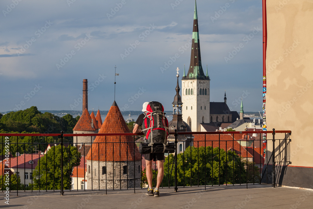 Obraz premium Man (hiker) enjoys cityscape of summer old Tallinn