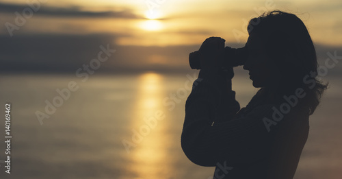 Clouds sky and sunlight sunset on horizon ocean. Silhouette person tourist traveler photographer making pictures seascape on photo camera on background sunrise. mockup evening nature