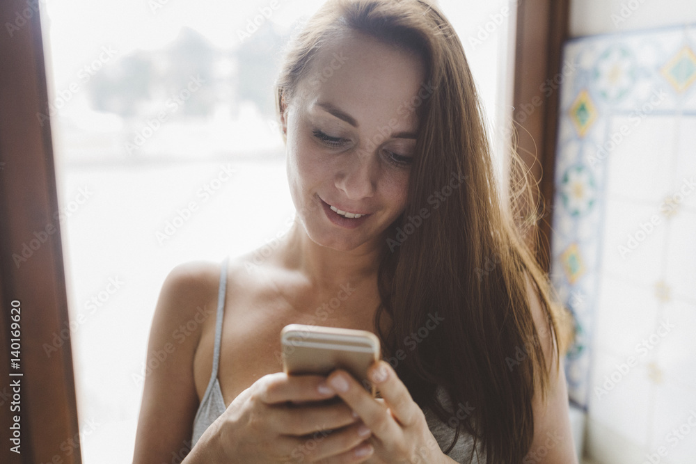 Woman at home checking the cell phone Woman at home checking the cell phone