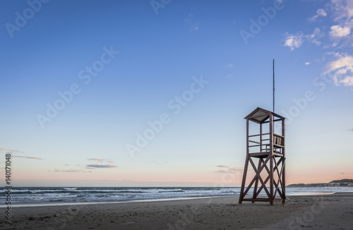 Beach sunrise with lifeguard wooden tower
