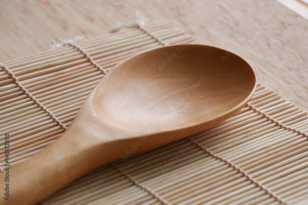 Ladle wooden on bamboo mat in the kitchen Ladle wooden on bamboo mat in the kitchen