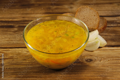 Fresh pea soup in glass bowl on wooden table