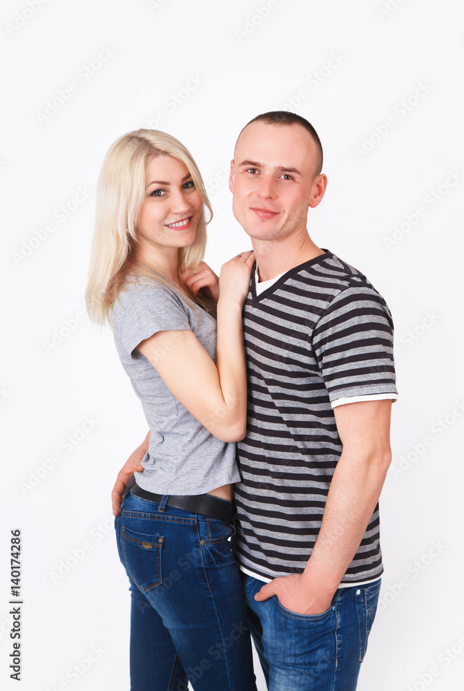 Young man and woman standing hugging in a studio. Young man and woman standing hugging in a studio.