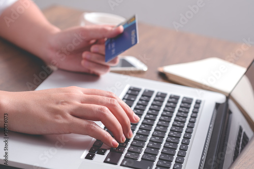 Close up hand holding credit card and using laptop. Online shopping