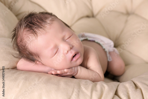 Cute little baby sleeping on lounge at home