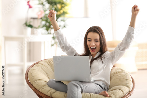 Young woman with laptop sit...