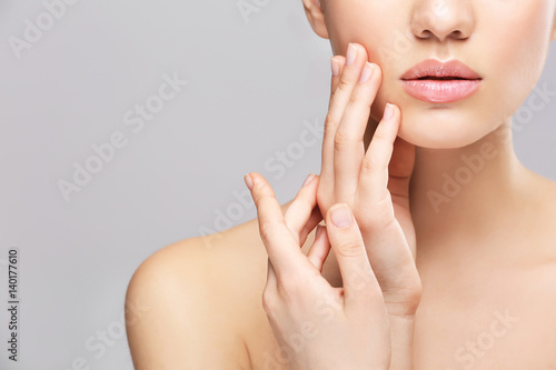 Face of young woman on light background