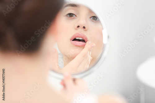 Young woman with cold sore ...