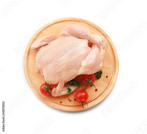 Cutting board with raw chicken and tomatoes on white background