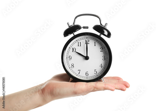 Female hand holding alarm clock on white background