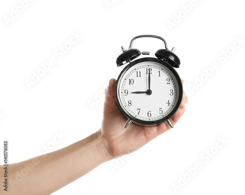 Female hand holding alarm clock on white background