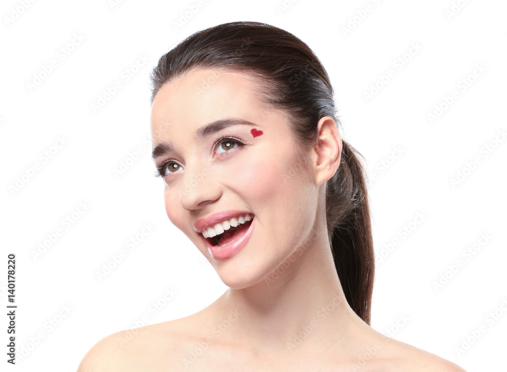 Beautiful young woman with heart painted on face, against white background Beautiful young woman with heart painted on face, against white background