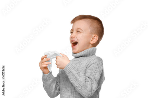 Cute little boy sneezing in...