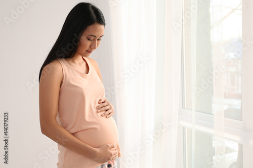 Pregnant Asian woman near window at home Free Download Pregnant Asian woman near window at home - GFXLoad