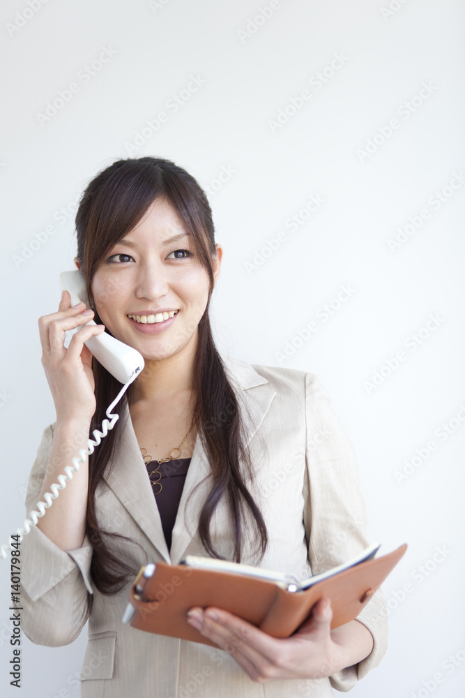 Businesswoman holding a diary and on the phone Businesswoman holding a diary and on the phone