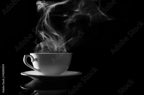 Steaming cup of coffee on black background