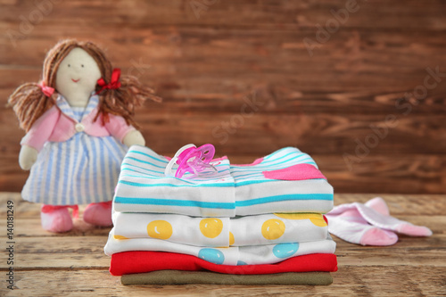 Pile of baby clothes on woo...