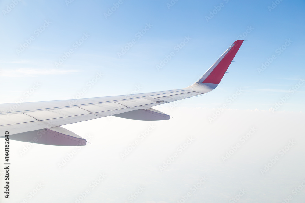 Wing of an airplane flying above the blue sky and clouds. Wing of an airplane flying above the blue sky and clouds.