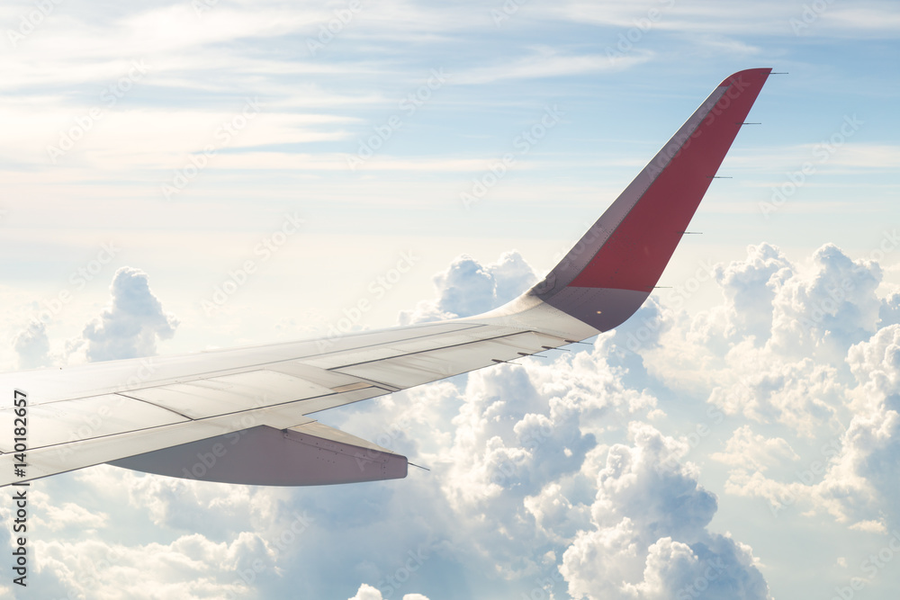 Wing of an airplane flying above the blue sky and clouds. Wing of an airplane flying above the blue sky and clouds.