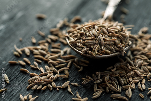 Obraz na płótnie Cumin seeds in metal spoon on a wooden table, horizontal, selective focus w salonie