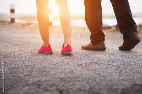 Closeup silhouette of loving couple holding hands while walking at sunset 