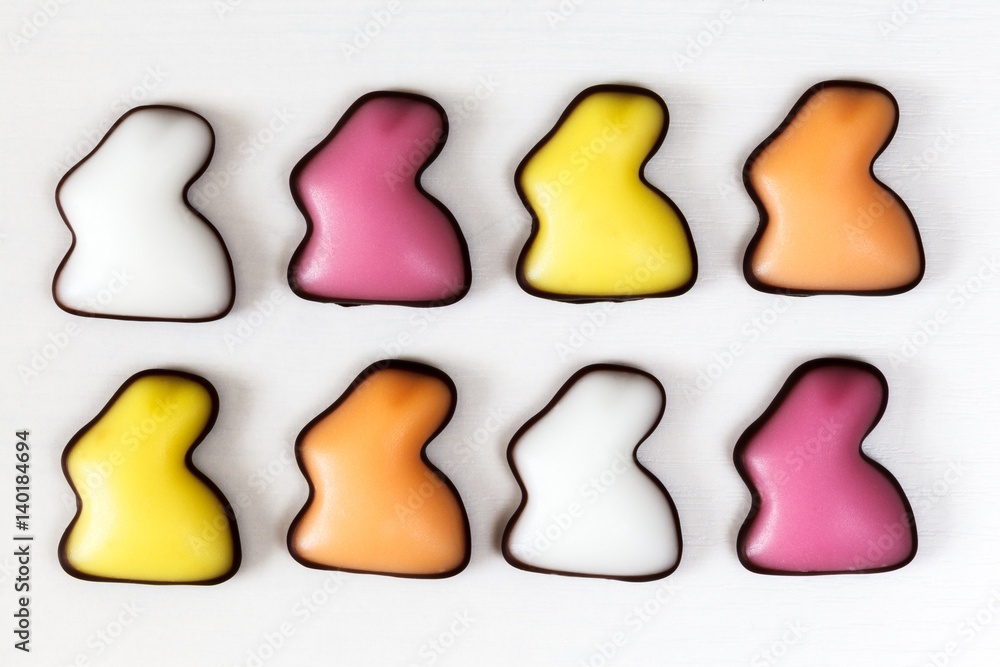 Acht Fondant-Osterhasen auf einem Holztisch Acht Fondant-Osterhasen auf einem Holztisch