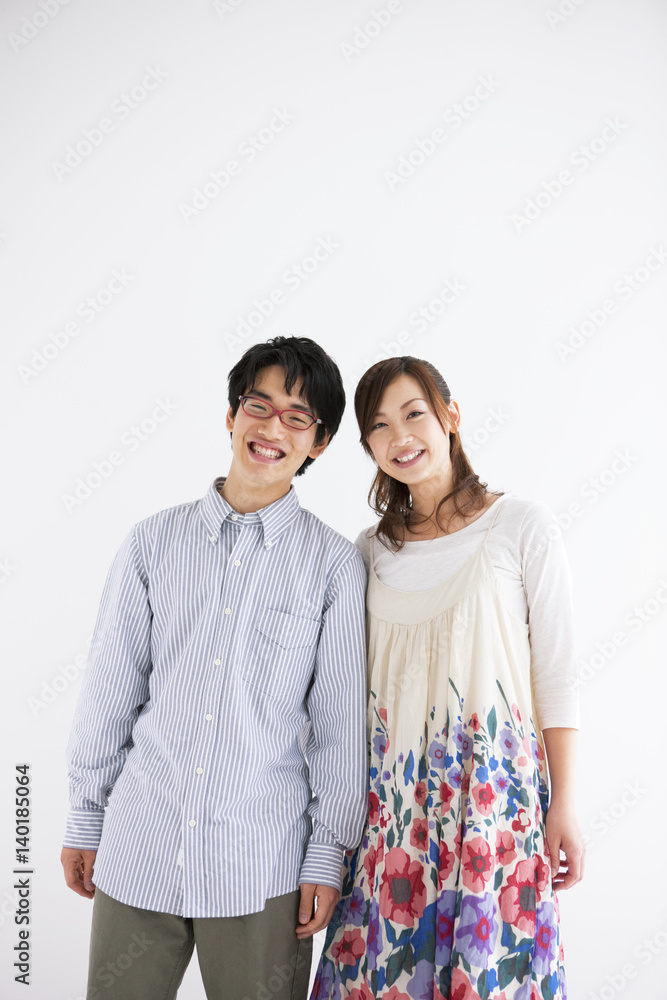 Young couple standing side by side and smiling Young couple standing side by side and smiling