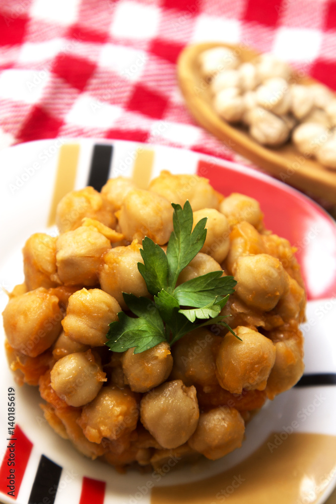 Chickpeas with tomato and carrot on wooden table plate