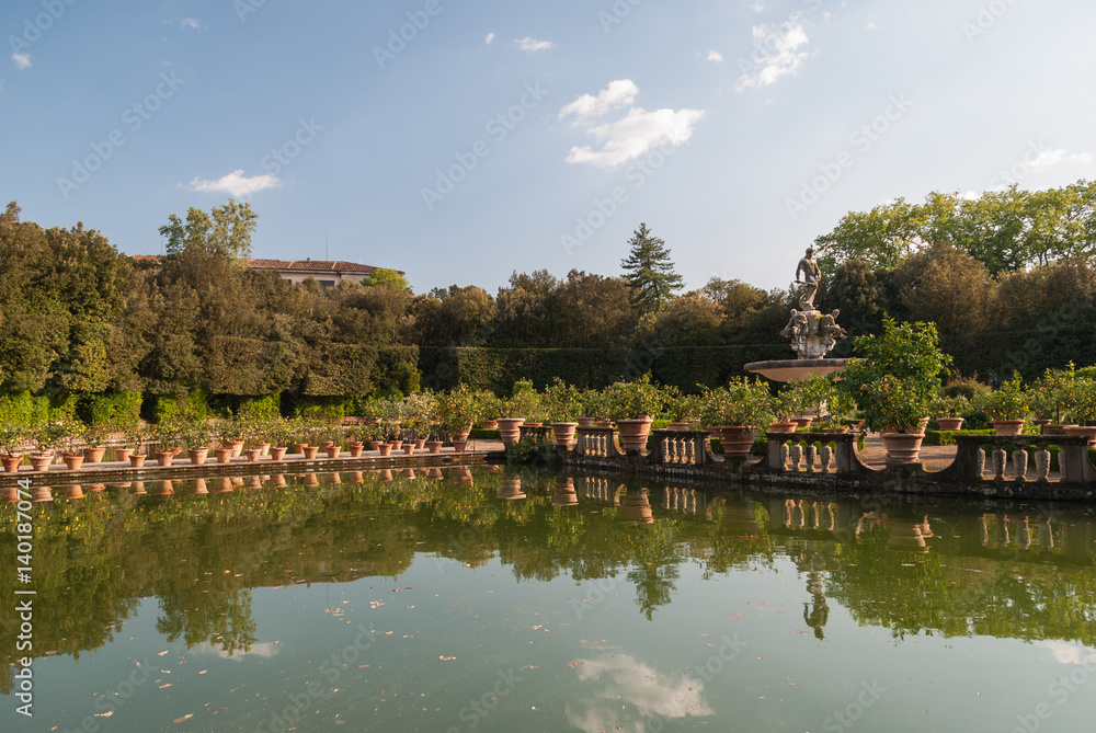 Italian garden with mediterranean plants reflecting in the lake