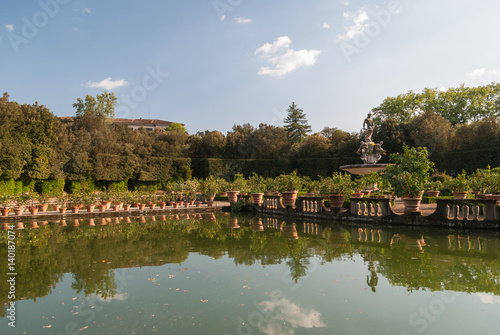 Italian garden with mediterranean plants reflecting in the lake