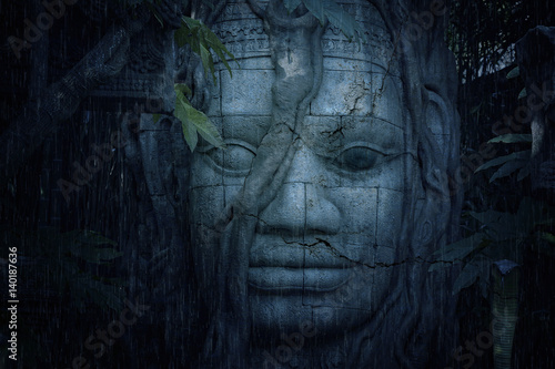 Ancient face at a mysterious ruins in jungle photo