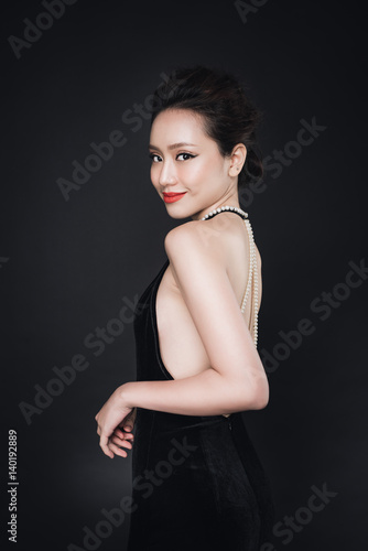Asian woman with fashion makeup in luxury black dress.