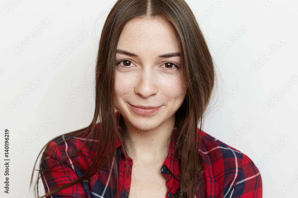 Portrait of beautiful teenage girl with messy hair and cute smile wearing red checkered shirt posing isolated at white studio wall. Headshot of young Caucasian brunette female dressed casually Portrait of beautiful teenage girl with messy hair and cute smile wearing red checkered shirt posing isolated at white studio wall. Headshot of young Caucasian brunette female dressed casually