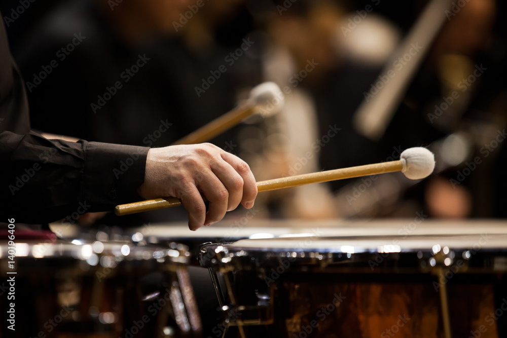 Naklejka premium Wręcza muzyka bawić się timpani w orkiestry zbliżeniu w ciemnych kolorach