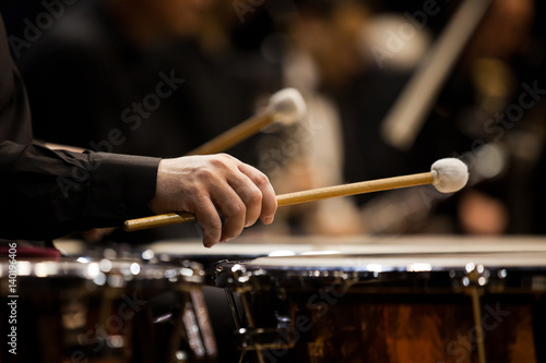 Foto Hands musician playing the timpani in the orchestra closeup in dark colors